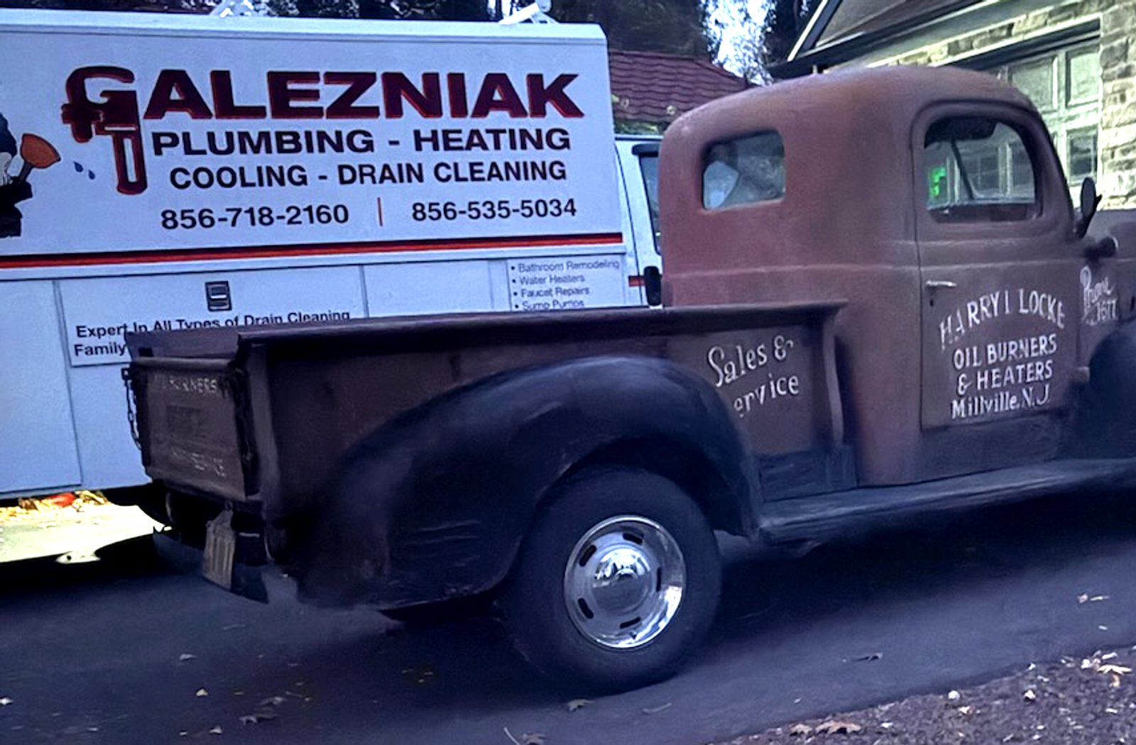 The modern Galezniak service van beside a vintage 1940s oil-burner service pickup, both in South Jersey